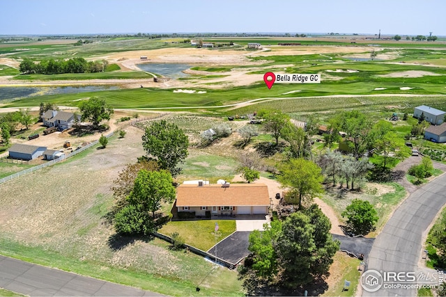 aerial view of property's location featuring a golf course and a large body of water