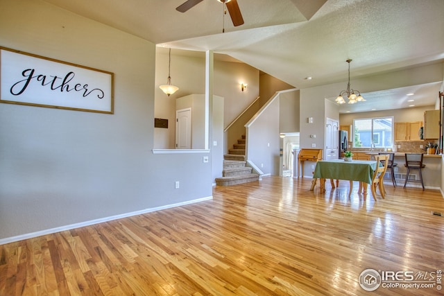 2069 Vineyard Ct, Windsor, CO 80550 - living room with light wood finished floors, stairs, a ceiling fan, baseboards, and high vaulted ceiling
