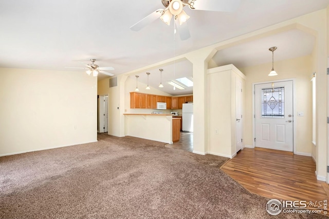 955 Sunchase Dr, Fort Collins, CO 80524 - unfurnished living room featuring a ceiling fan, light colored carpet, lofted ceiling, and baseboards