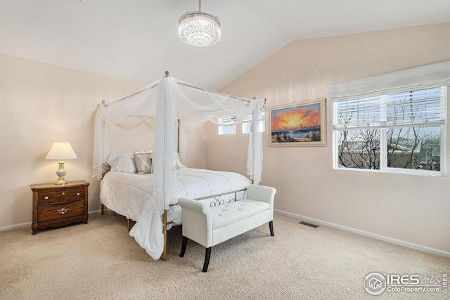 carpeted bedroom featuring lofted ceiling, a chandelier, and baseboards