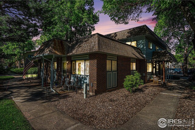 1001 Strachan Dr Unit 24, Fort Collins, CO 80525 - view of side of property with brick siding, mansard roof, and a porch