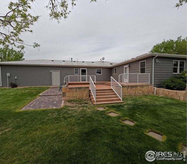 22198 County Road 25, Fort Morgan, CO 80701 - back of house featuring a deck, a patio area, and a lawn