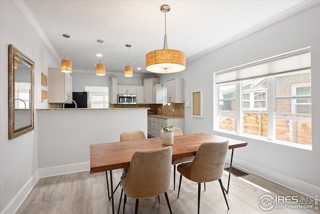 3039 W Denver Pl, Denver, CO 80211 - dining area with crown molding, plenty of natural light, light wood-style flooring, and baseboards