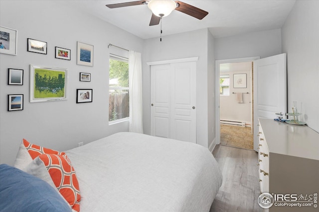 3039 W Denver Pl, Denver, CO 80211 - bedroom with light wood-style floors, a baseboard heating unit, a closet, and ceiling fan