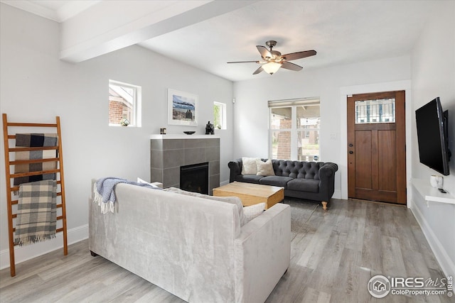 3039 W Denver Pl, Denver, CO 80211 - living room with light wood-style floors, a tiled fireplace, healthy amount of natural light, and a ceiling fan