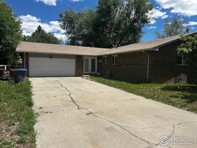 712 Meeker St, Longmont, CO 80504 - single story home featuring french doors, brick siding, a garage, and concrete driveway
