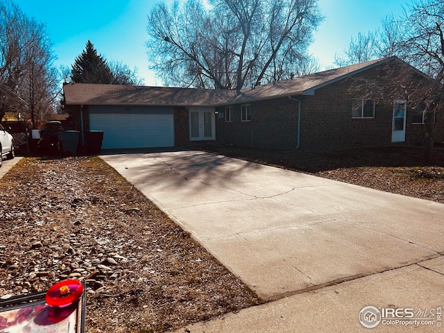 712 Meeker St, Longmont, CO 80504 - single story home featuring french doors, a garage, concrete driveway, and brick siding