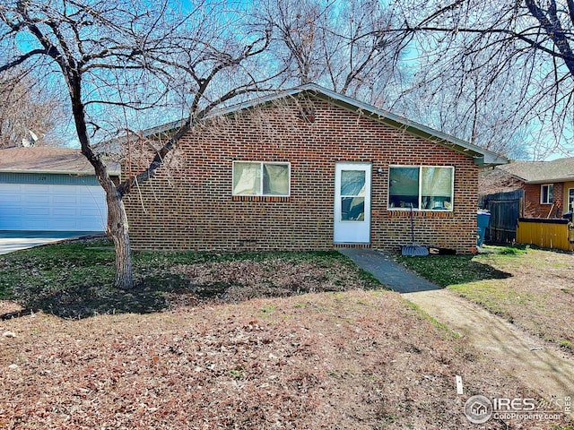 712 Meeker St, Longmont, CO 80504 - bungalow-style home featuring an attached garage, concrete driveway, and brick siding