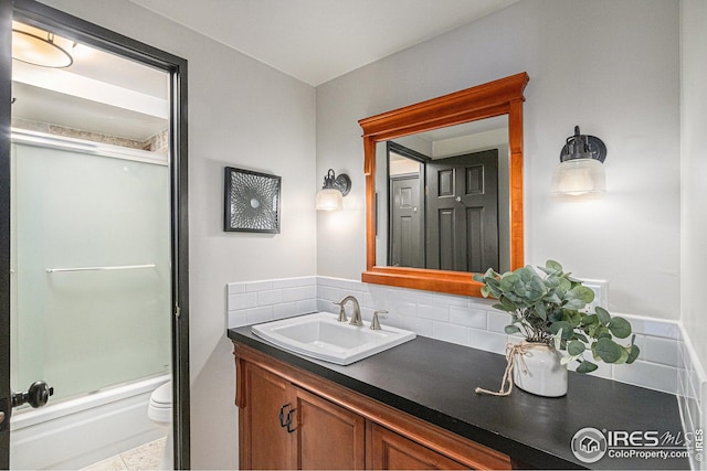 415 S Howes St Unit 202, Fort Collins, CO 80521 - bathroom featuring vanity, toilet, backsplash, and shower / bath combination with glass door