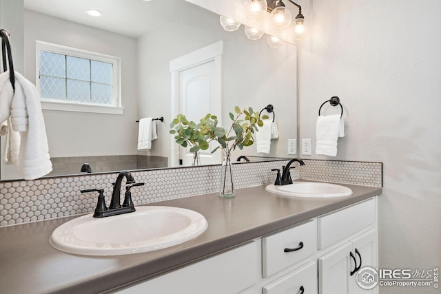 2497 Trio Falls Dr, Loveland, CO 80538 - bathroom featuring double vanity and backsplash