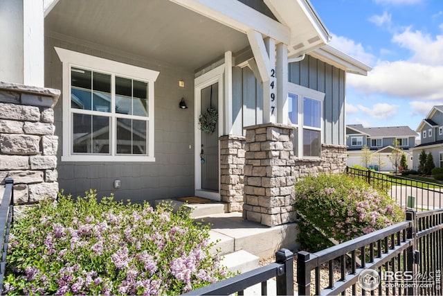 2497 Trio Falls Dr, Loveland, CO 80538 - view of exterior entry featuring stone siding, a residential view, and a porch