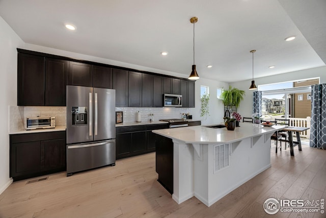 542 Highlands Cir, Erie, CO 80516 - kitchen featuring stainless steel appliances, a sink, decorative backsplash, recessed lighting, and light wood-style floors