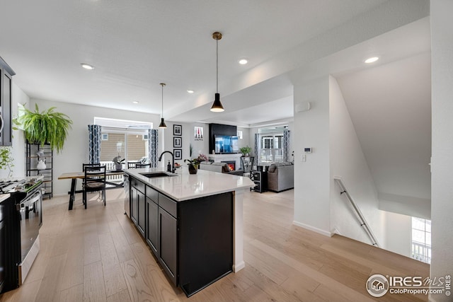 542 Highlands Cir, Erie, CO 80516 - kitchen with a sink, range with gas cooktop, light countertops, open floor plan, and light wood finished floors