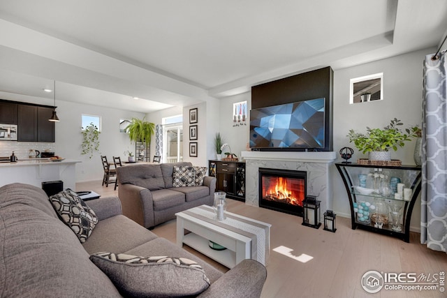 542 Highlands Cir, Erie, CO 80516 - living room with a high end fireplace, light wood finished floors, baseboards, and recessed lighting