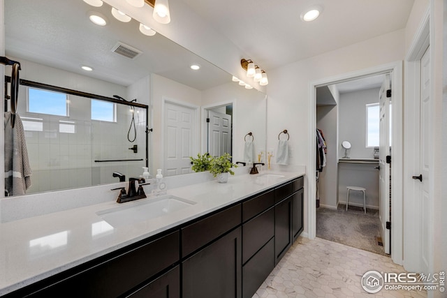 542 Highlands Cir, Erie, CO 80516 - full bathroom with double vanity, tiled shower, recessed lighting, a walk in closet, and tile patterned flooring