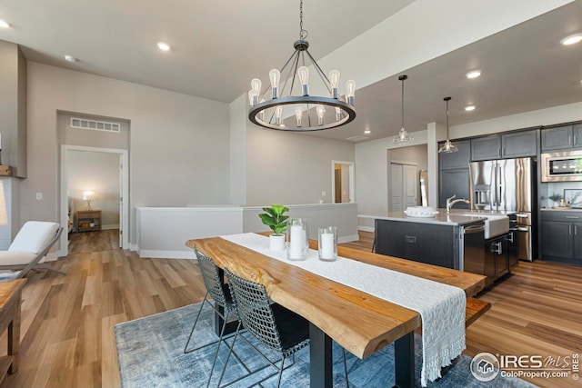 6752 Castello St, Timnath, CO 80547 - dining room with light wood finished floors, a chandelier, recessed lighting, baseboards, and lofted ceiling