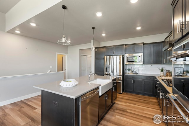 6752 Castello St, Timnath, CO 80547 - kitchen featuring stainless steel appliances, a sink, light wood finished floors, tasteful backsplash, and recessed lighting