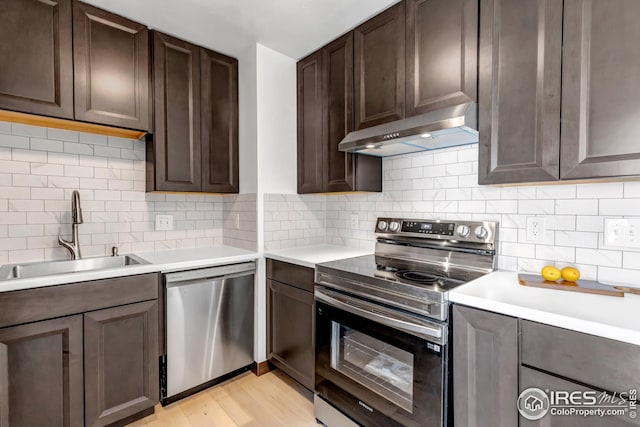 1006 4th St, Pierce, CO 80650 - kitchen with appliances with stainless steel finishes, under cabinet range hood, a sink, light countertops, and dark brown cabinets
