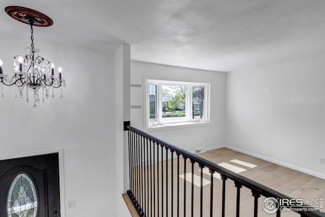 1006 4th St, Pierce, CO 80650 - hallway featuring a chandelier, wood finished floors, and baseboards