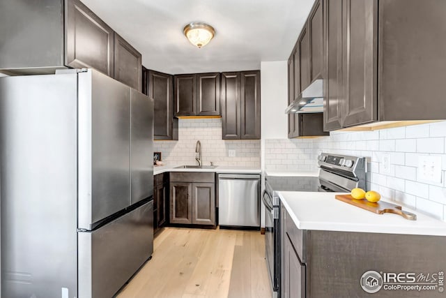 1006 4th St, Pierce, CO 80650 - kitchen featuring stainless steel appliances, a sink, exhaust hood, and dark brown cabinets
