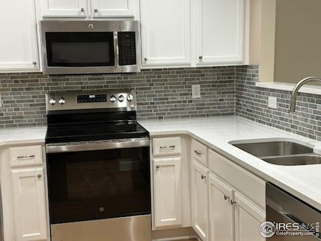 2218 Stetson Creek Dr Unit C, Fort Collins, CO 80528 - kitchen featuring appliances with stainless steel finishes, a sink, white cabinets, and light countertops