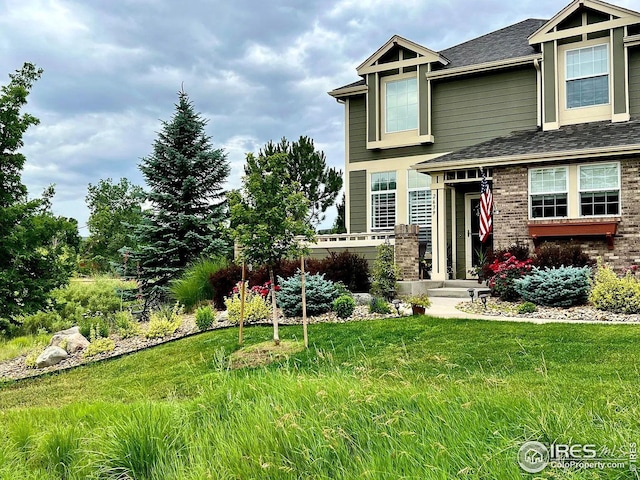 2639 County Fair Ln, Fort Collins, CO 80528 - view of front facade with roof with shingles, a front yard, and brick siding