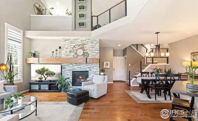 2639 County Fair Ln, Fort Collins, CO 80528 - living area with stairway, a towering ceiling, wood finished floors, a glass covered fireplace, and baseboards