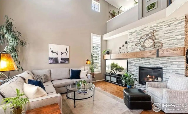 2639 County Fair Ln, Fort Collins, CO 80528 - living room with wood finished floors, a towering ceiling, a fireplace, and baseboards