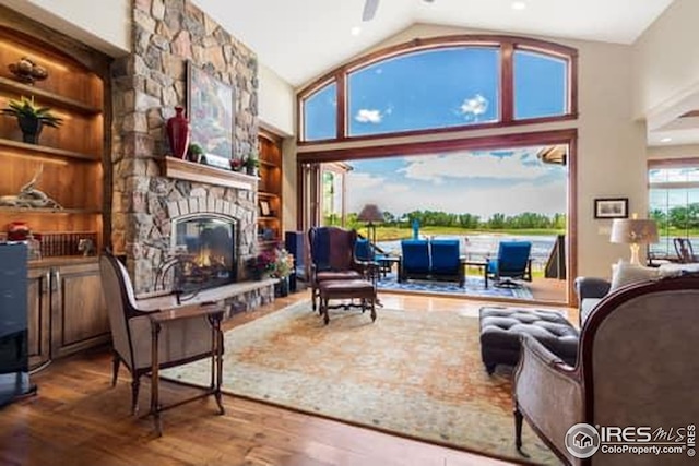 1812 Seashell Ct, Windsor, CO 80550 - living area featuring a fireplace, wood finished floors, and high vaulted ceiling