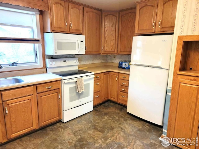 402 N Washington Ave, Fleming, CO 80728 - kitchen featuring white appliances, a sink, light countertops, brown cabinets, and stone finish flooring