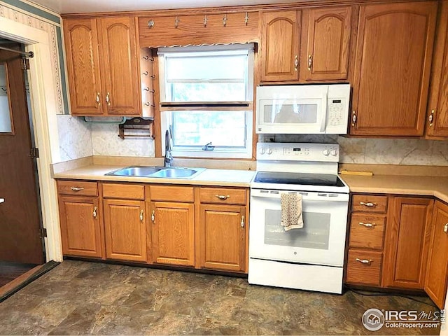 402 N Washington Ave, Fleming, CO 80728 - kitchen with white appliances, a sink, and brown cabinetry