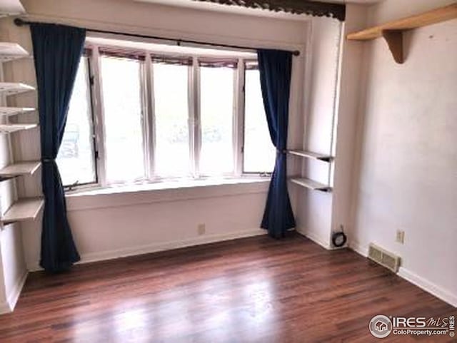 402 N Washington Ave, Fleming, CO 80728 - unfurnished room with dark wood-style floors, plenty of natural light, and baseboards
