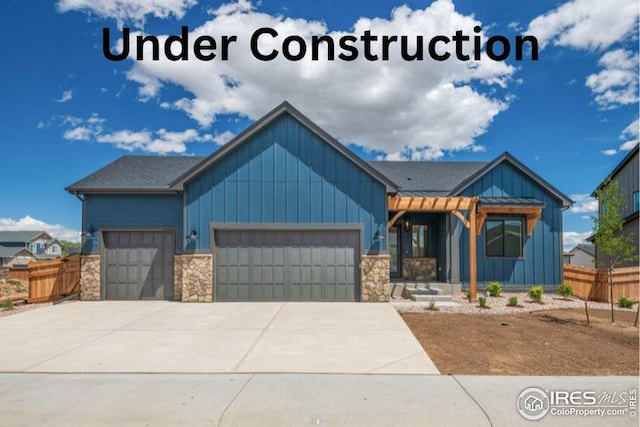 27 Snowcap Dr, Windsor, CO 80550 - view of front of property with board and batten siding, an attached garage, stone siding, and driveway
