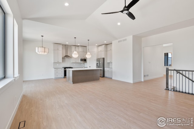 27 Snowcap Dr, Windsor, CO 80550 - kitchen with open floor plan, stainless steel appliances, wall chimney range hood, a ceiling fan, and vaulted ceiling