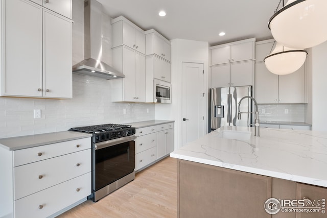 27 Snowcap Dr, Windsor, CO 80550 - kitchen with wall chimney range hood, appliances with stainless steel finishes, a sink, white cabinetry, and tasteful backsplash
