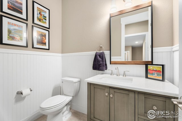 1030 Larimer Ridge Pkwy, Timnath, CO 80547 - bathroom featuring wainscoting, vanity, toilet, and tile patterned flooring