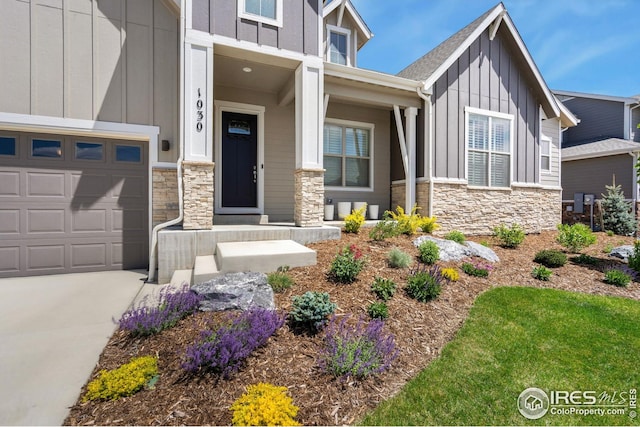 1030 Larimer Ridge Pkwy, Timnath, CO 80547 - view of front of house featuring board and batten siding, stone siding, a garage, concrete driveway, and covered porch