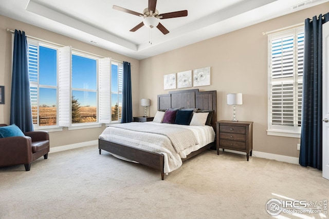 1030 Larimer Ridge Pkwy, Timnath, CO 80547 - carpeted bedroom featuring a tray ceiling, multiple windows, baseboards, and a ceiling fan