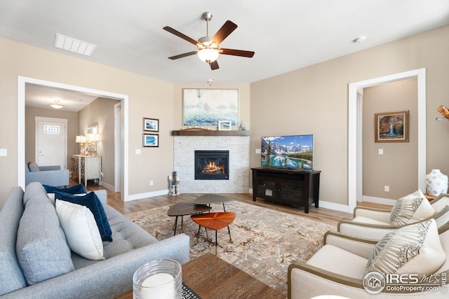 1030 Larimer Ridge Pkwy, Timnath, CO 80547 - living room with wood finished floors, ceiling fan, a glass covered fireplace, and baseboards