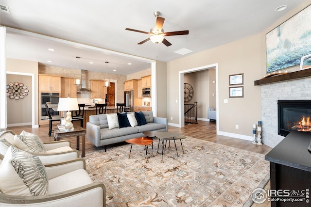 1030 Larimer Ridge Pkwy, Timnath, CO 80547 - living room featuring a ceiling fan, light wood-type flooring, baseboards, a glass covered fireplace, and recessed lighting
