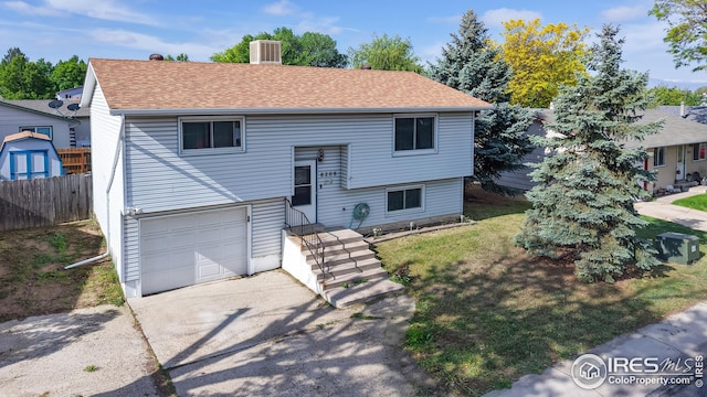 8208 Peakview Dr, Fort Collins, CO 80528 - split foyer home featuring a garage, concrete driveway, central air condition unit, and roof with shingles
