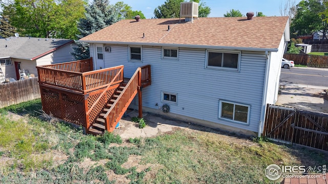 8208 Peakview Dr, Fort Collins, CO 80528 - back of house with a deck, a fenced backyard, roof with shingles, stairs, and central AC