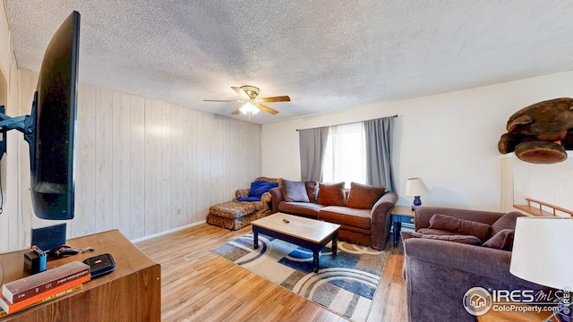 8208 Peakview Dr, Fort Collins, CO 80528 - living room with wood finished floors, a ceiling fan, wood walls, baseboards, and a textured ceiling