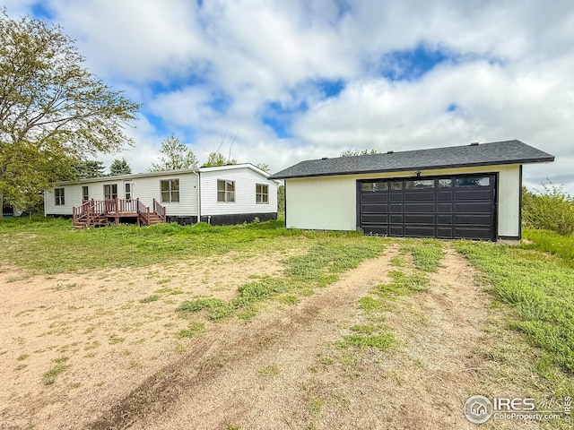 306 E Arapahoe St, Fleming, CO 80728 - view of front of house featuring driveway, a wooden deck, and an attached garage