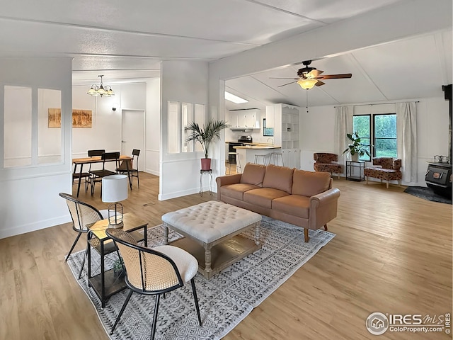 306 E Arapahoe St, Fleming, CO 80728 - living area featuring a wood stove, light wood-style flooring, a ceiling fan, and a chandelier