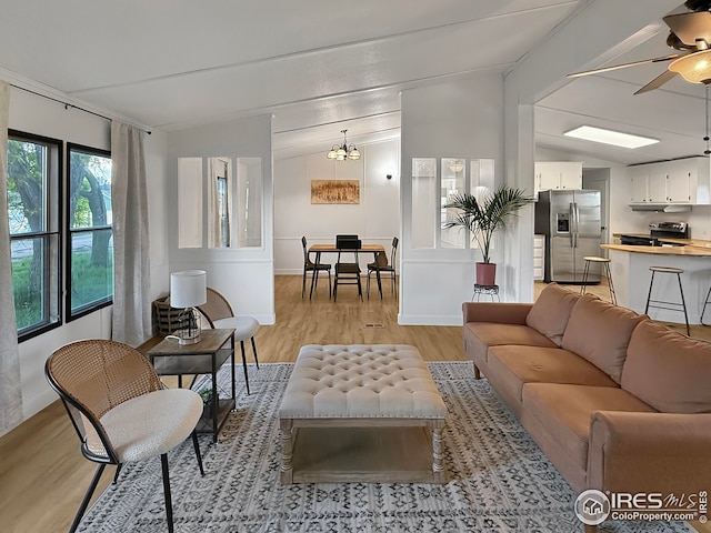306 E Arapahoe St, Fleming, CO 80728 - living room with lofted ceiling, light wood finished floors, ceiling fan, and a chandelier