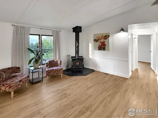 306 E Arapahoe St, Fleming, CO 80728 - sitting room with light wood-style flooring, a wood stove, and vaulted ceiling