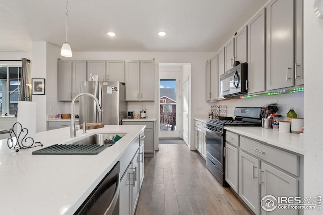 1958 Autumn Moon Dr, Windsor, CO 80550 - kitchen featuring appliances with stainless steel finishes, gray cabinetry, light countertops, wood finished floors, and recessed lighting