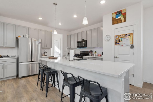 1958 Autumn Moon Dr, Windsor, CO 80550 - kitchen featuring appliances with stainless steel finishes, gray cabinetry, light wood-style floors, and recessed lighting