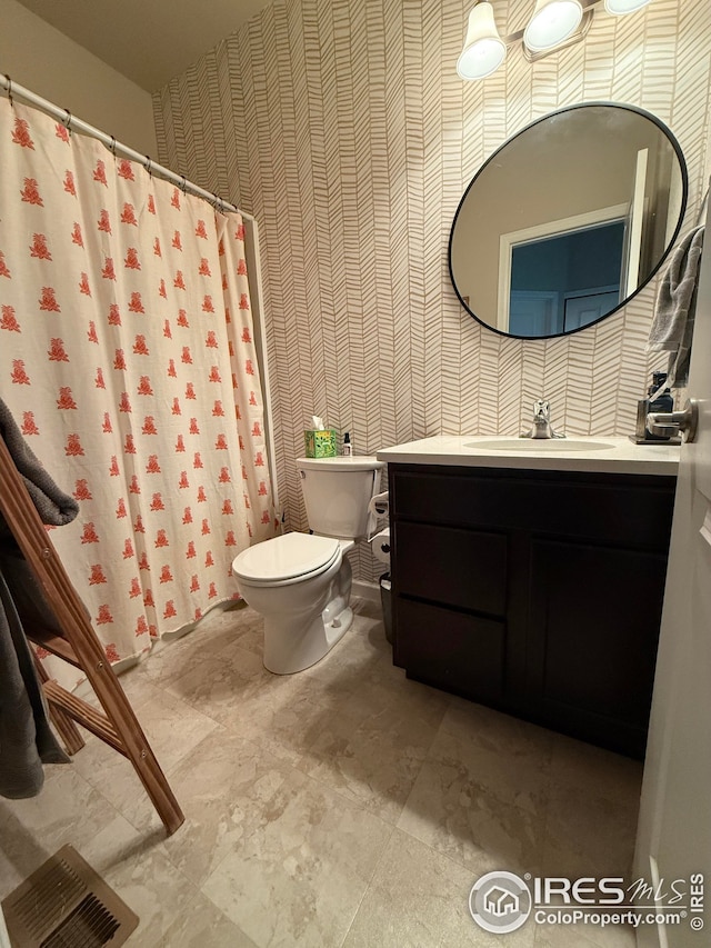 706 S Prairie Dr, Milliken, CO 80543 - bathroom with wallpapered walls, toilet, vanity, and a shower with curtain